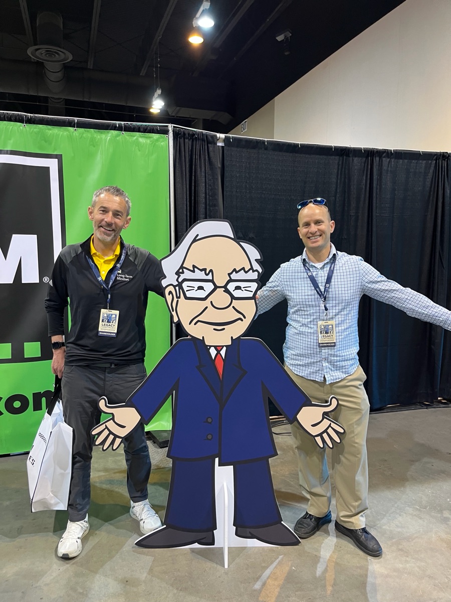 Attendees posing with a Warren Buffett cutout