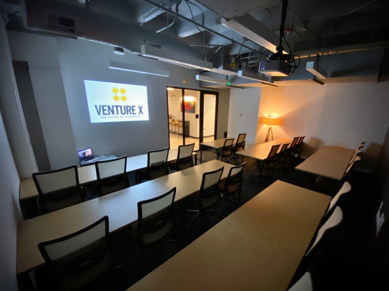 A programming room at Venture X set up with seating and a screen